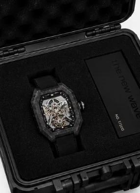 Project 2 with the black strap in its black presentation case, beside the numbered the new wave plate