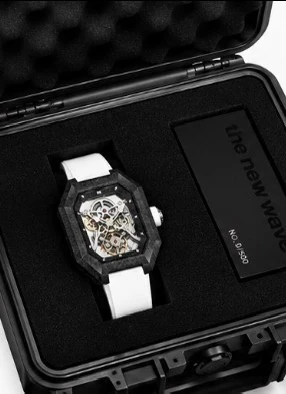 Project 2 with the white strap in its black presentation case, beside the numbered the new wave plate